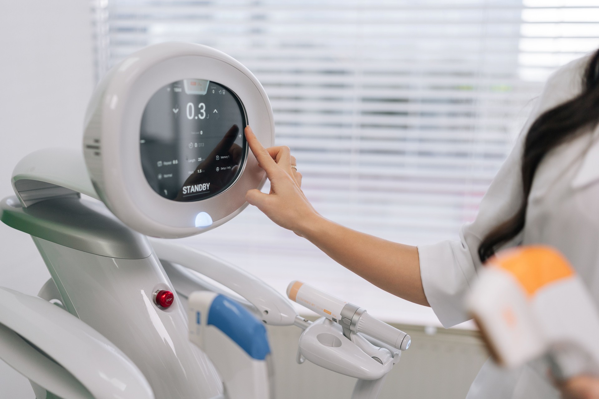 Cropped shot of cosmetologist female adjusting settings on cosmetic ultrasound device touchscreen, preparing for professional facial lifting and skin rejuvenation procedure in modern beauty clinic
